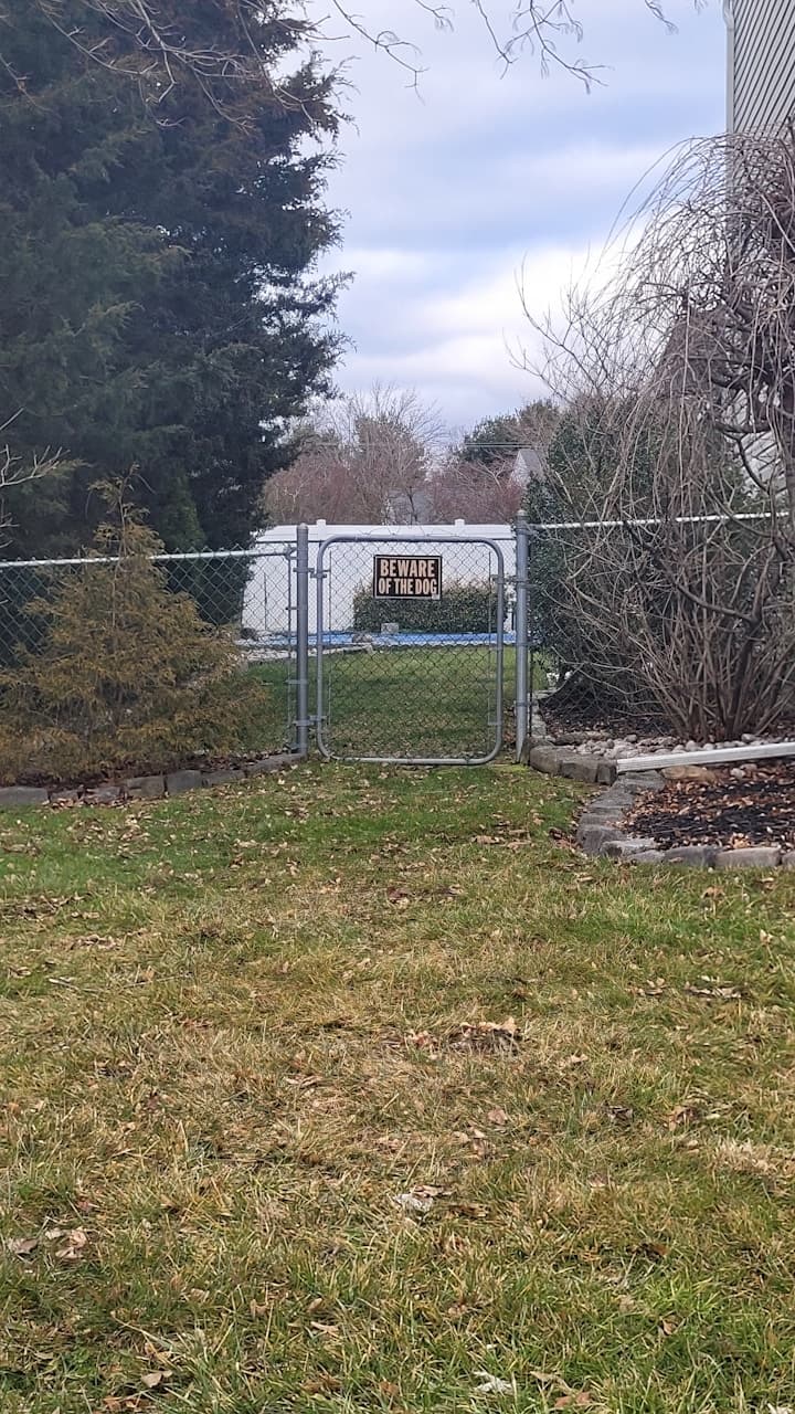 Fenced backyard with a visible warning sign.